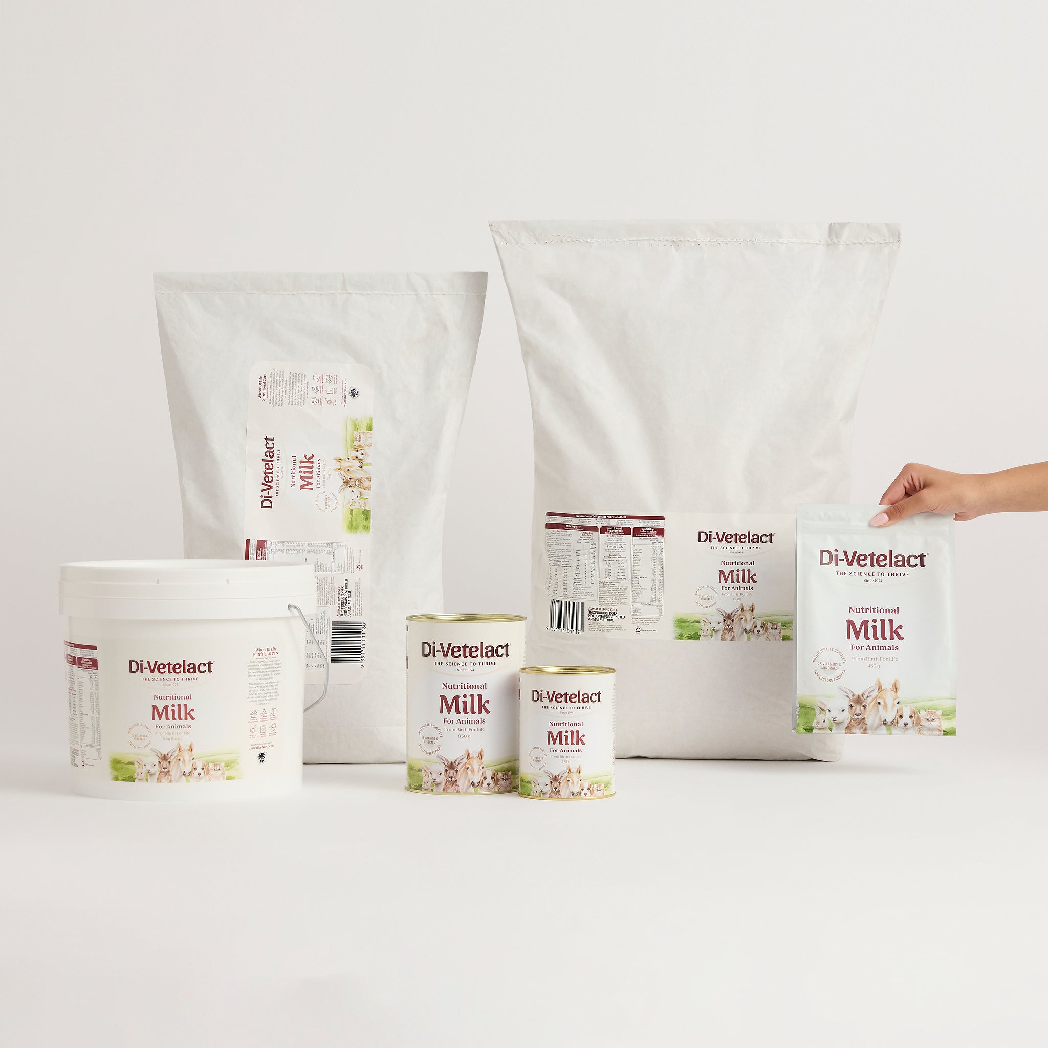 Di-Vetelact Nutritional Milk range of Products on a light background with had lifting the 450g pouch