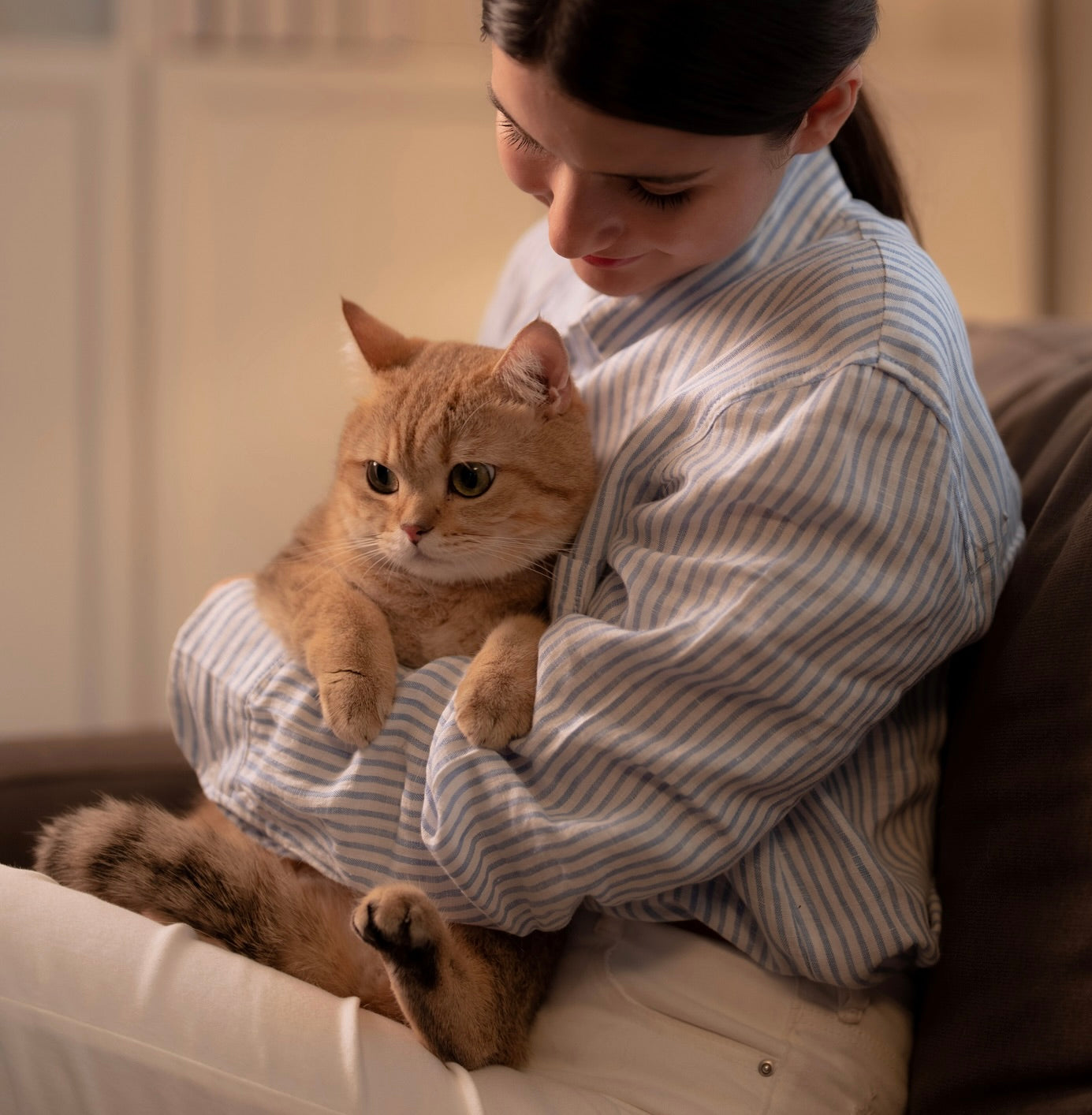 Woman holding orange cat